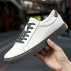 Men's Leather-Look Low-Top Trainers - Lace-Up Plain Toe - Gray & White, held in hand